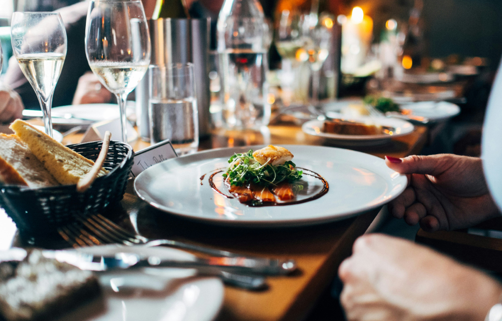 A beautifully arranged table featuring plates of food and elegant wine glasses, inviting a delightful dining experience