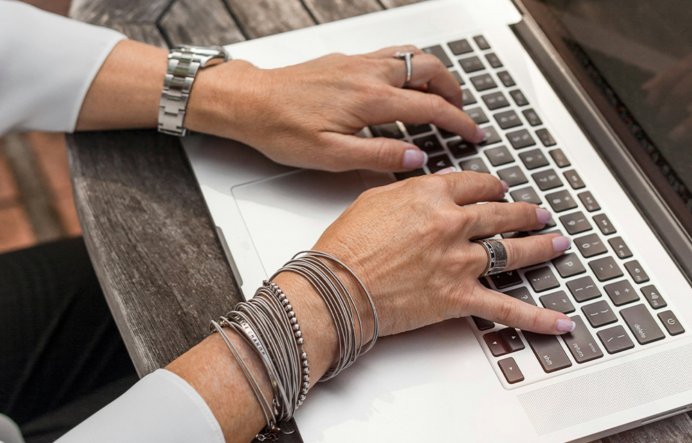 A woman engaged in typing on a laptop